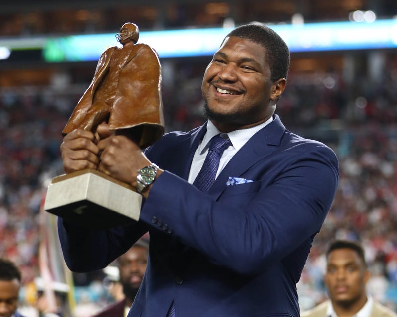Ravens D-lineman holds up the Walter Payton Man of the Year Award during Super Bowl LIV