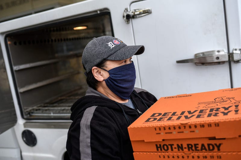 Little Caesars Pizza delivery driver carrying boxes