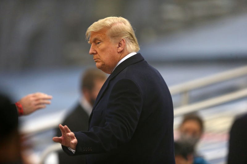 President Donald Trump waves as he walks out of the stadium during the first half of the Army-Navy game at Michie Stadium