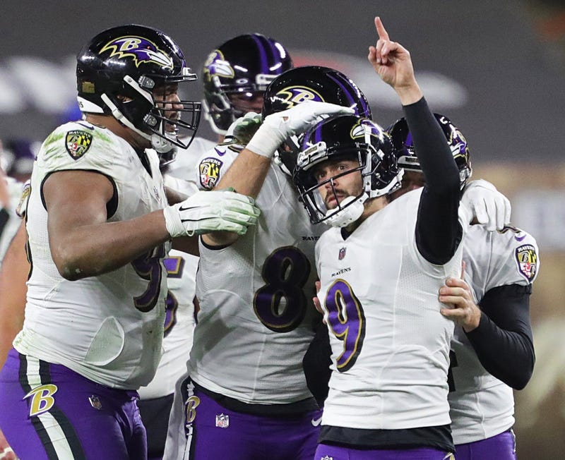 Justin Tucker is swarmed by his teammates after hitting the game-winning kick against the Browns.