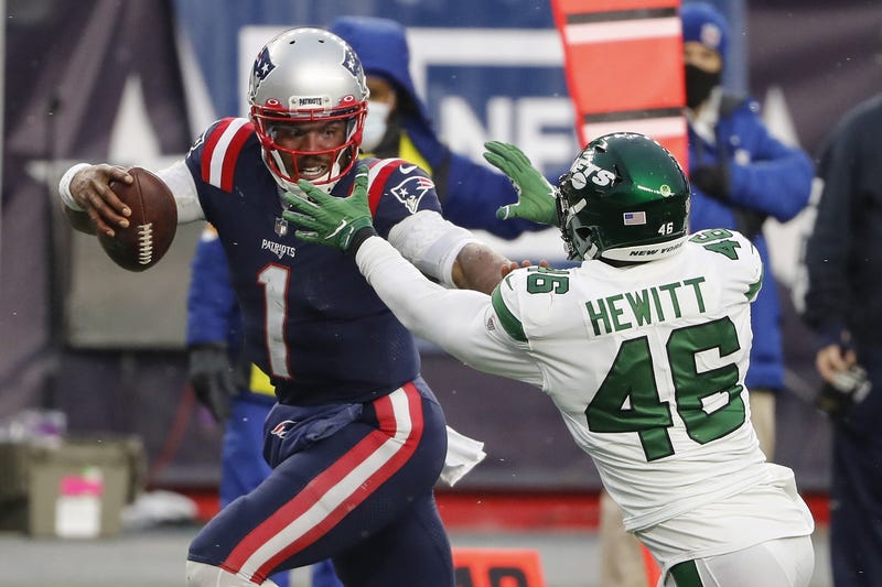 New England Patriots quarterback Cam Newton (1) fights off New York Jets linebacker Neville Hewitt (46) on his way to a touchdown during the second half at Gillette Stadium.