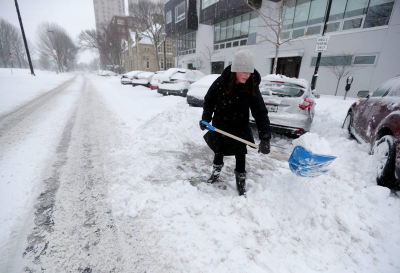 Erin Flora of Milwaukee clears snow from her car near the corner of East Kilbourn Avenue and North Cass Street on Sunday, Jan. 31, 2021, in Milwaukee. Parts of Milwaukee and Ozaukee counties were dumped on with around 10 inches of snow overnight as a snowstorm moved in and then lake effect snow added to the accumulation. 