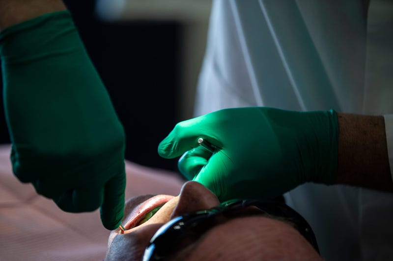 A dentist pulls a patient's tooth.