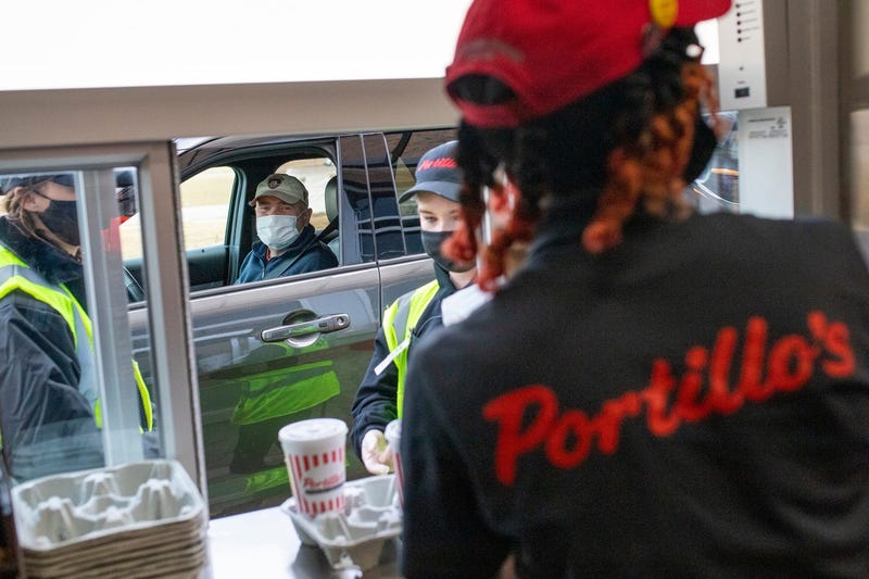 A customer picks up their order in Portillo's drive-thru