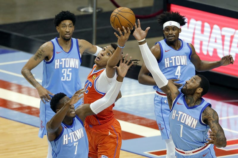 ﻿Oklahoma City Thunder center Moses Brown, middle, reaches for a rebound between, from left, Houston Rockets guard Victor Oladipo (7) center Christian Wood (35), forward Danuel House Jr. (4) and guard John Wall (1) during the second half of an NBA basketball game Sunday, March 21, 2021, in Houston.