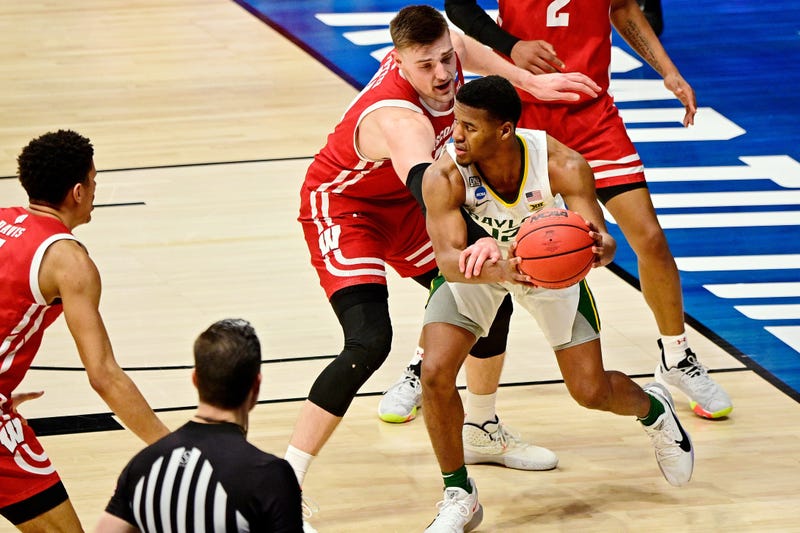 Wisconsin Badgers forward Micah Potter (11) reaches for the ball while defending Baylor Bears guard Jared Butler (12) during the second half in the second round of the 2021 NCAA Tournament at Hinkle Fieldhouse. The Baylor Bears won 76-63.
