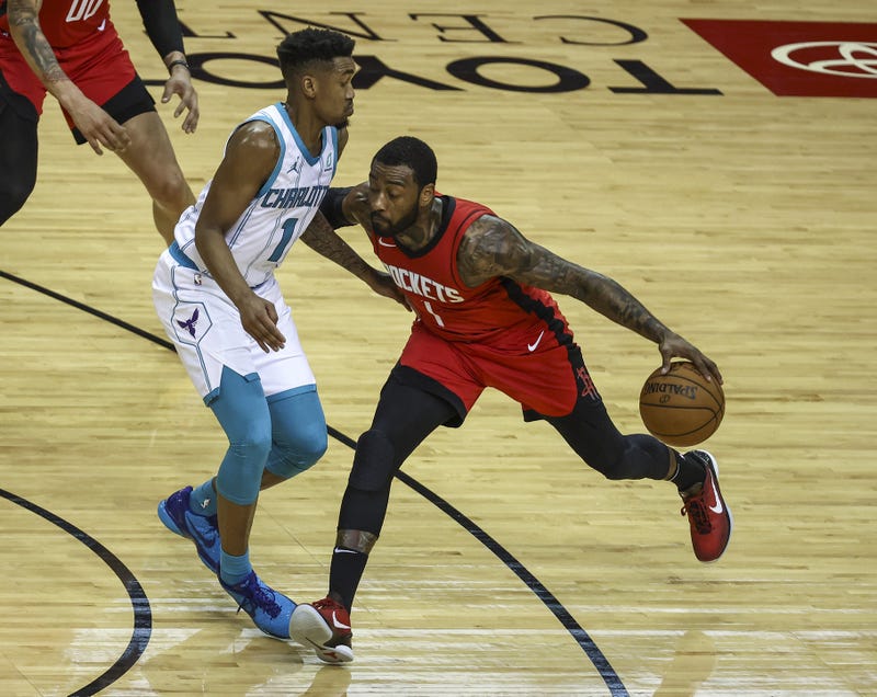 Houston Rockets guard John Wall (1) dribbles the ball as Charlotte Hornets guard Malik Monk (1) defends during the fourth quarter at Toyota Center.