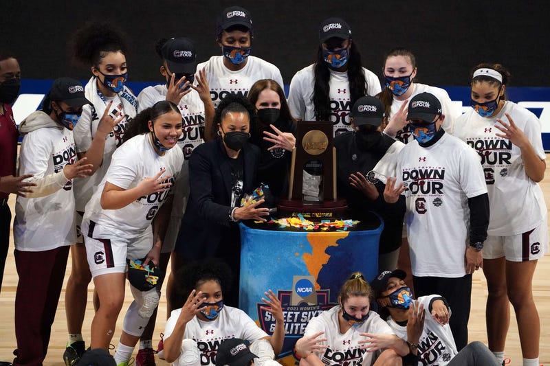 South Carolina Gamecocks players and coach Dawn Staley pose with the regional champion trophy after defeating the Texas Longhorns at Alamodome.