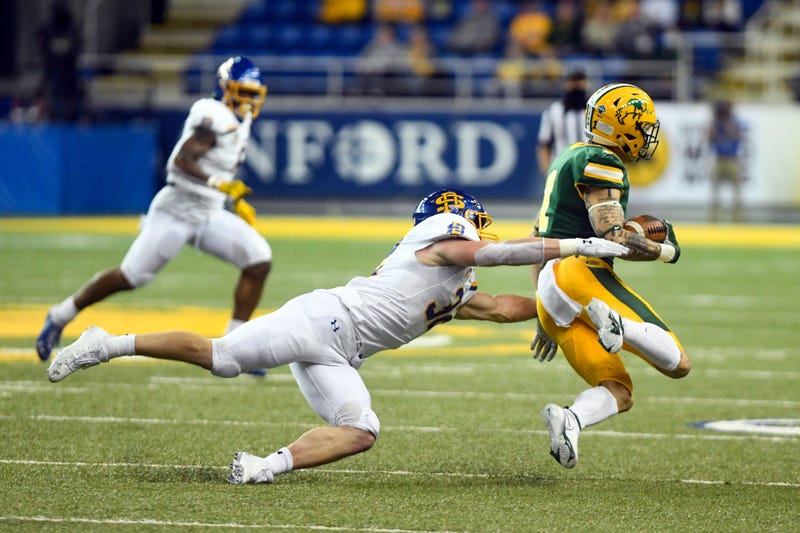 South Dakota State's Adam Bock tackles North Dakota State's Christian Watson during the Dakota Marker rivalry game on Saturday, April 17, 2021, at the Fargodome in Fargo. Dakota