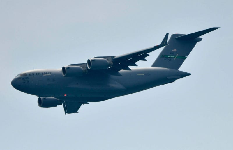 A C-17 cargo plane flies over the crowd at an air show.