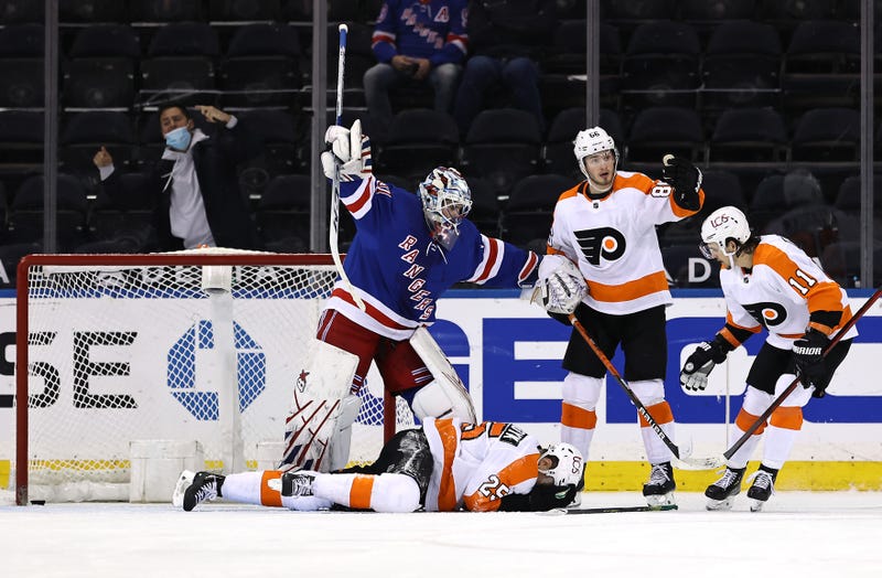 Igor Shesterkin of the New York Rangers signals for help after James van Riemsdyk of the Philadelphia Flyers falls to the ice after a puck went into the net off of his face.