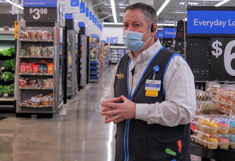Store manager of a Walmart Supercenter meets with employees