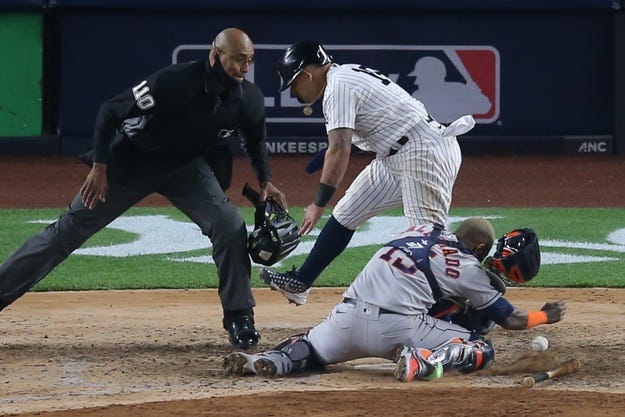 New York Yankees second baseman Rougned Odor (18) collides with Houston Astros catcher Martin Maldonado (15) while scoring on a hit by Yankees first baseman DJ LeMahieu (not pictured) during the sixth inning.