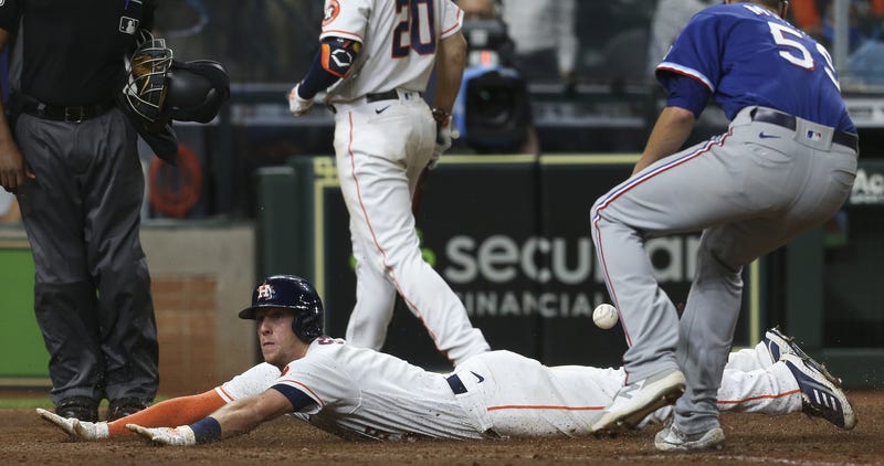 Houston Astros center fielder Myles Straw (3) scores on a wild pitch as Texas Rangers relief pitcher Brett Martin (59) is late with the tag in the11th inning at Minute Maid Park.