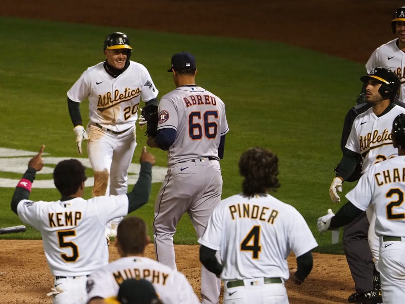 Oakland Athletics left fielder Mark Canha (20) celebrates with center fielder Ramon Laureano (22) after Laureano hit a sacrifice fly off Houston Astros pitcher Bryan Abreu (66) to send Canha in for a run for a walk-off win during the ninth inning at RingCentral Coliseum.