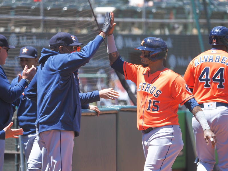Houston Astros catcher Martin Maldonado (15) high fives manager Dusty Baker Jr (left) after scoring a run against the Oakland Athletics during the third inning at RingCentral Coliseum.