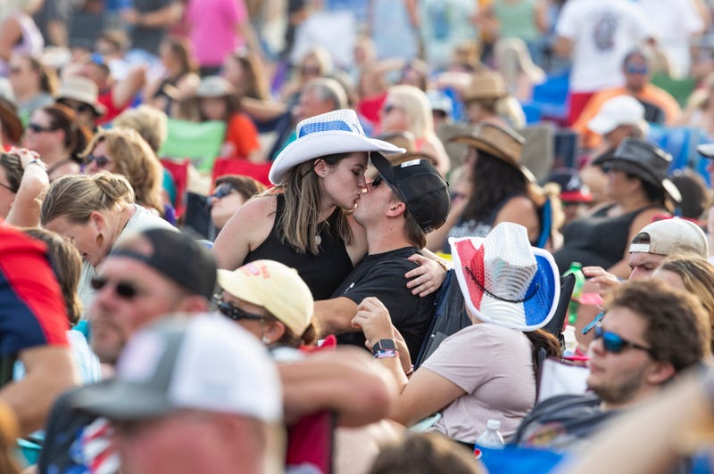 A couple kiss in the middle of a crowd during a three-day music festival in Panama City Beach called the Gulf Coast Jam.
