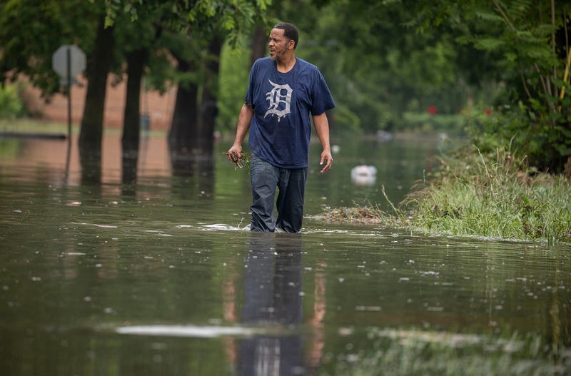 Richard Davis, of Detroit, holds debris he pulled off of the storm drain to the side on June 26, 2021, as he came to help his neighbors at the intersection of Essex Avenue and Kitchener Street after heavy rains in Metro Detroit caused massive flooding in homes, streets and freeways.