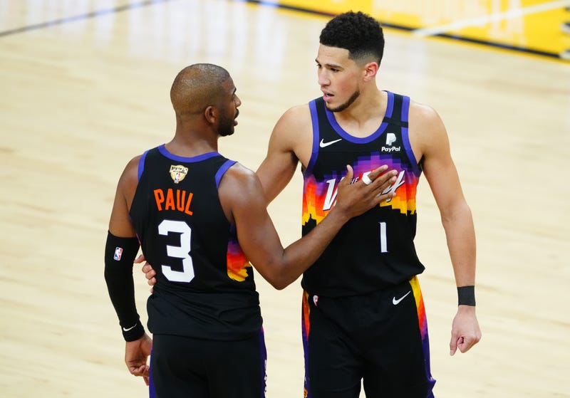Phoenix Suns guard Devin Booker (1) speaks with guard Chris Paul (3) against the Milwaukee Bucks during the second half in game one of the 2021NBA Finals at Phoenix Suns Arena.