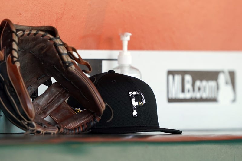 A Pittsburgh Pirates hat and glove sit in the dugout