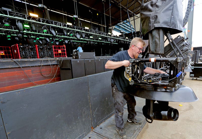 Peter Mahsem, with IATSE Local 18 labor union, works on setting up a lighting rig.