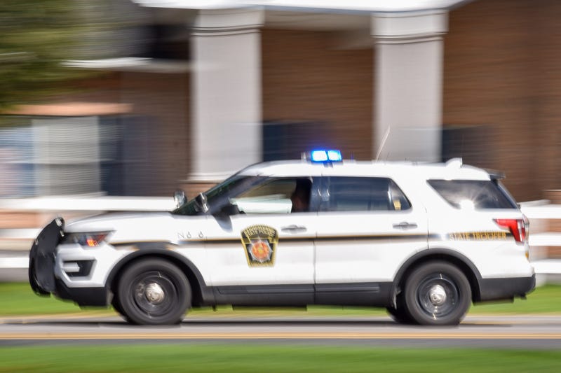A Pennsylvania State Police cruiser flies down the road.