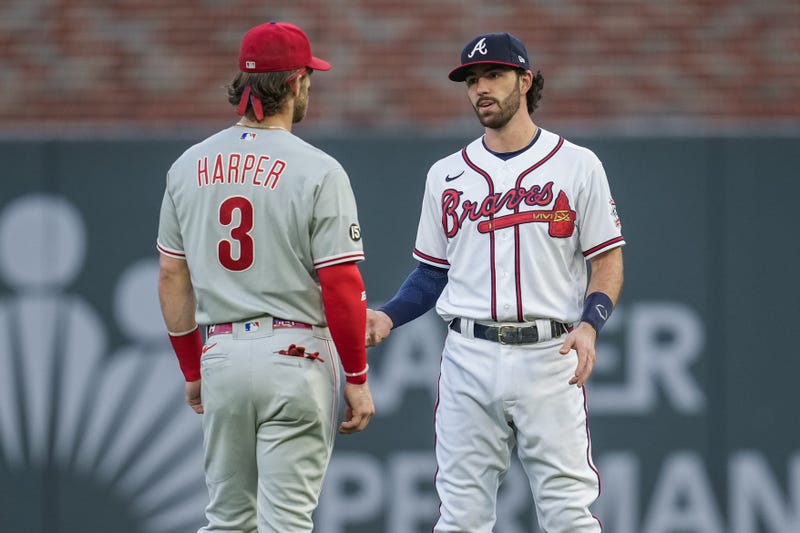 Philadelphia Phillies right fielder Bryce Harper talks to Atlanta Braves shortstop Dansby Swanson on the field before a game at Truist Park.