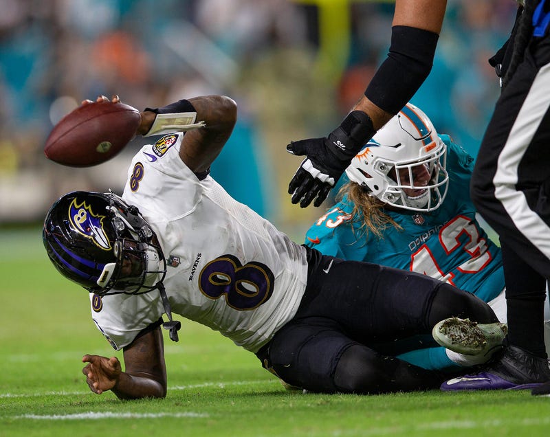 Lamar Jackson slams the ball in frustration after a sack