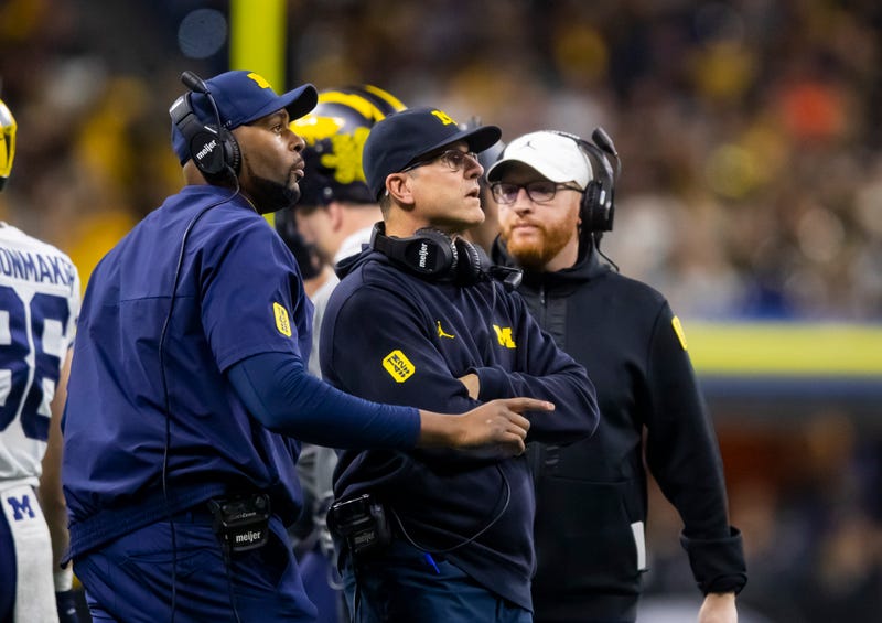 Sherrone Moore, left, and Jim Harbaugh on the sidelines