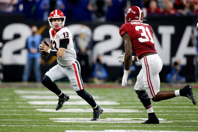 Georgia Bulldogs quarterback Stetson Bennett (13) scrambles with the ball as Alabama Crimson Tide linebacker Will Anderson Jr. (31) gives chase Monday, Jan. 10, 2022, during the College Football Playoff National Championship at Lucas Oil Stadium in Indianapolis.