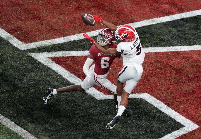 Jan 10, 2022; Indianapolis, IN, USA; Georgia Bulldogs wide receiver Adonai Mitchell (5) catches a touchdown pass over Alabama Crimson Tide defensive back Khyree Jackson (6) in the fourth quarter during the 2022 CFP college football national championship game at Lucas Oil Stadium.