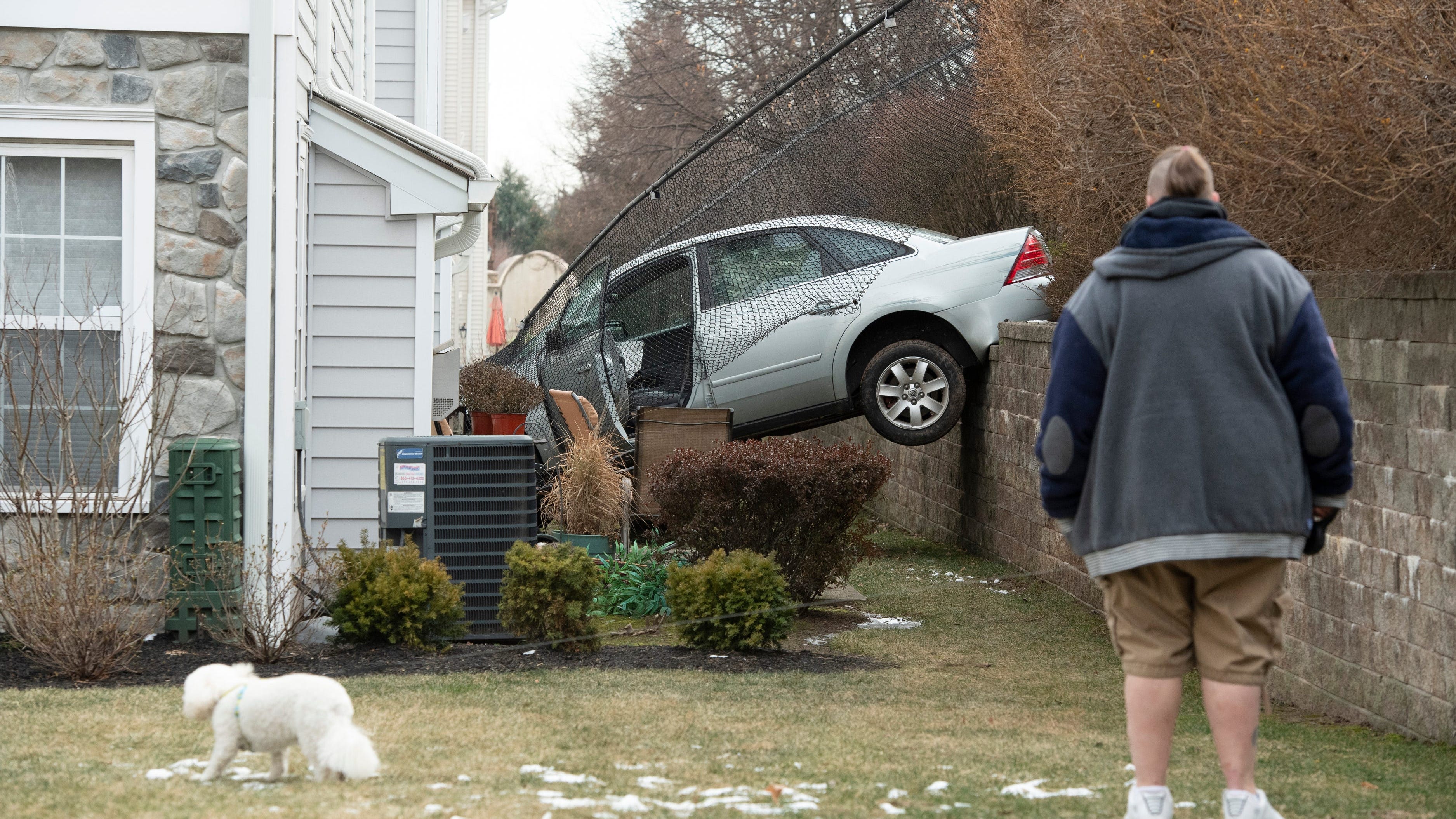 PHOTOS: Car plows into NJ home after veering off parkway, crashing through fence