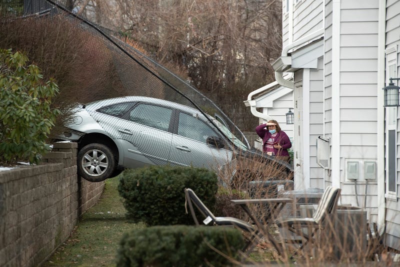 The vehicle traveled through backyards and crashed through a fence before landing in the townhouse, police said