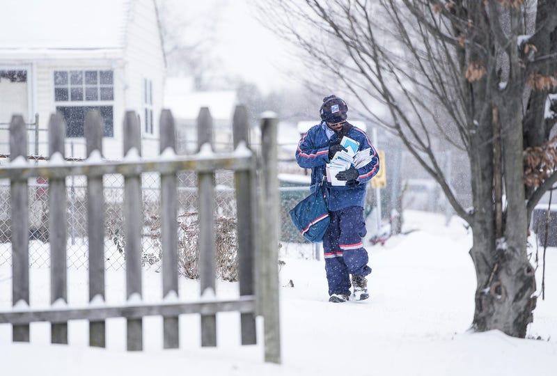 USPS postal carrier William Talley carries armfulls of mail through the snow along his route in South Linden on Monday, Jan. 24, 202