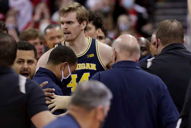 Wisconsin head coach Greg Gard, right, is involved in a scuffle with Michigan head coach Juwan Howard