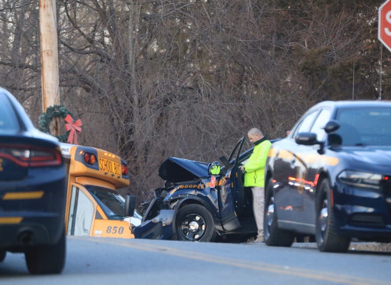 The crash between the school bus and the police car left one dead and four injured.
