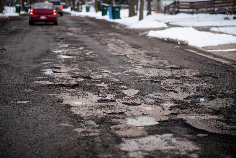 potholes pepper the street in the winter