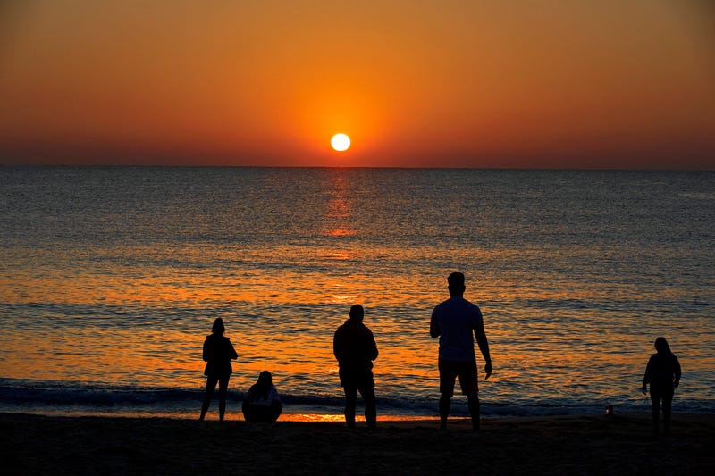 People gather for sunrise on Midtown Beach in Palm Beach
