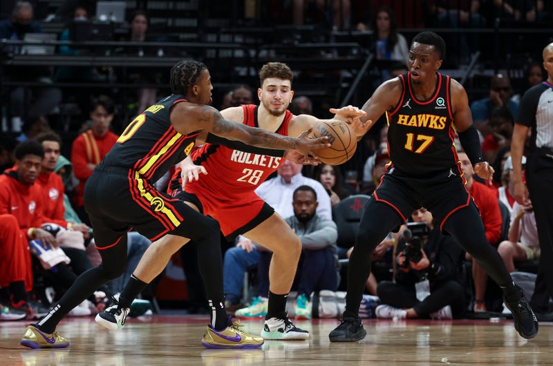 Apr 10, 2022; Houston, Texas, USA; Atlanta Hawks guard Delon Wright (0) and forward Onyeka Okongwu (17) attempt to steal the ball from Houston Rockets center Alperen Sengun (28) during the fourth quarter at Toyota Center. 