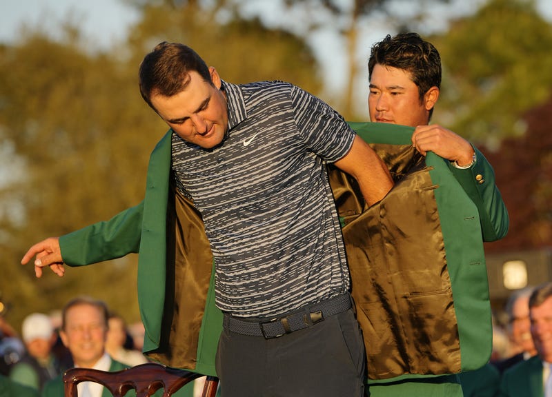 2021 Masters Champion Hideki Matsuyama puts the champion's green jacket on 2022 Masters Champion Scottie Scheffler during the Green Jacket Ceremony following the final round of the Masters Tournament at Augusta National Golf Club.