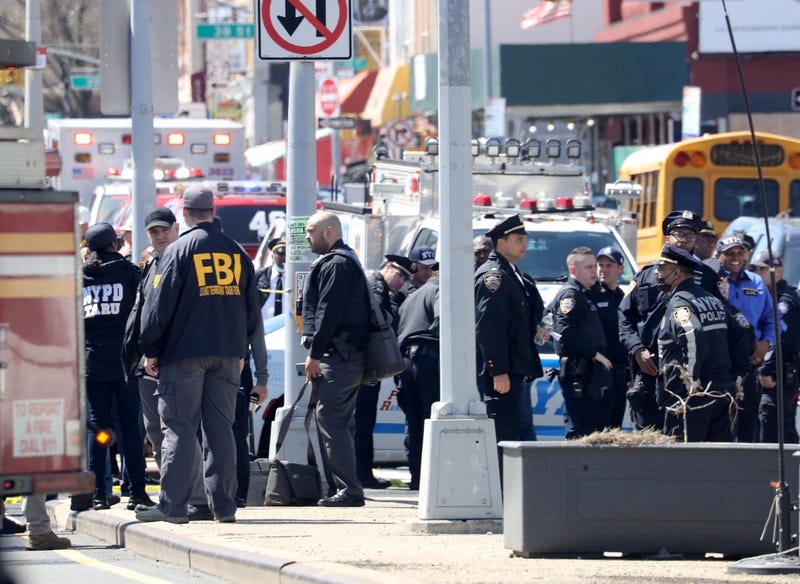 Members of the NYPD and other law enforcement agencies work near the scene of a subway shooting in Brooklyn April 12, 2022.