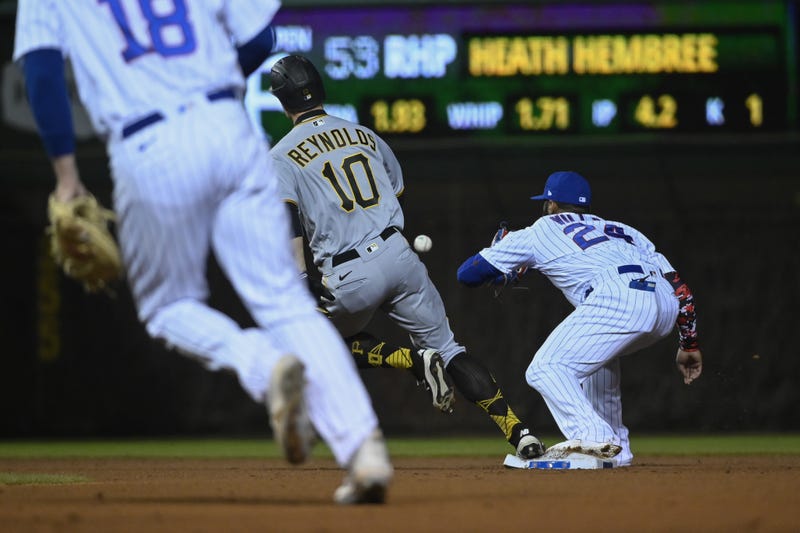 Bryan Reynolds (10) heads to third base as Chicago Cubs second baseman Jonathan Villar (24) gets the ball during the seventh inning at Wrigley Field. 