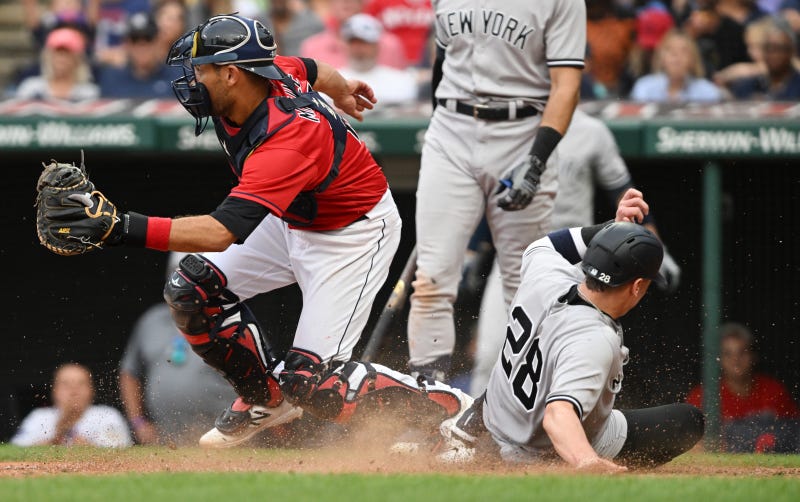 New York Yankees third baseman Josh Donaldson (28) scores as Cleveland Guardians catcher Luke Maile (12) waits for the throw during the seventh inning at Progressive Field.