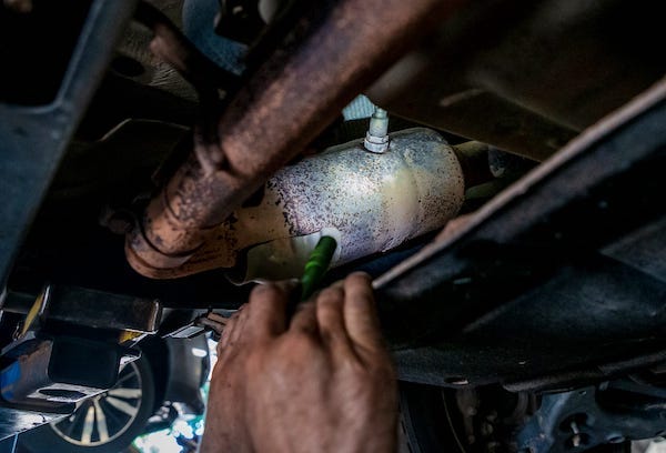Beck's Garage mechanic, Randal Lonkerd, points out a catalytic converter on a vehicle as he talks about the rise in converter theft