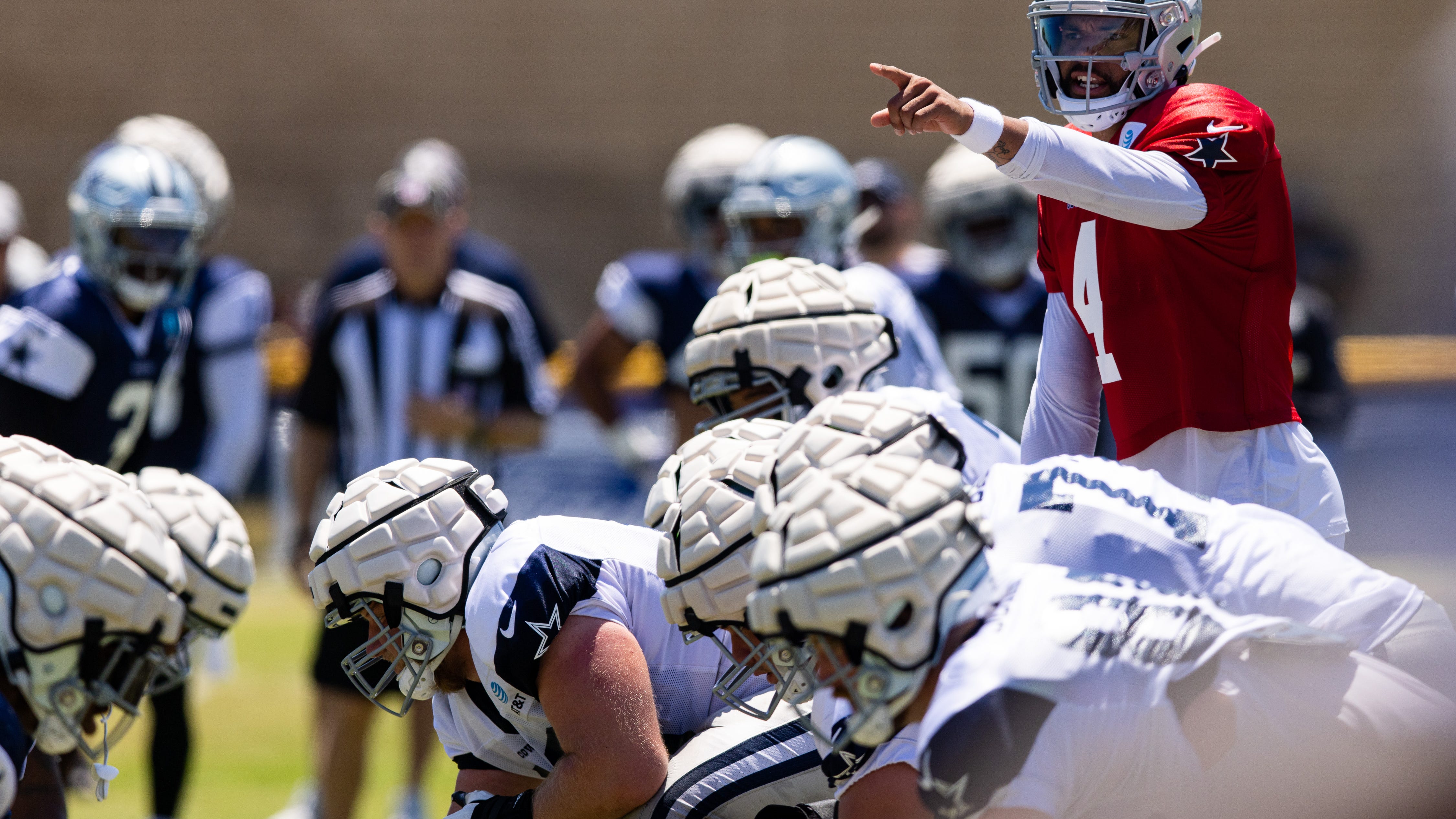 Who leads Cowboys starting OG, WR and DE competitions?