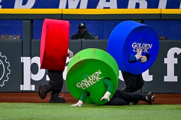The Oakland Athletics bullpen looks on as the red dot and green dot and blue dot race by during the sixth inning against the Texas Rangers at Globe Life Field