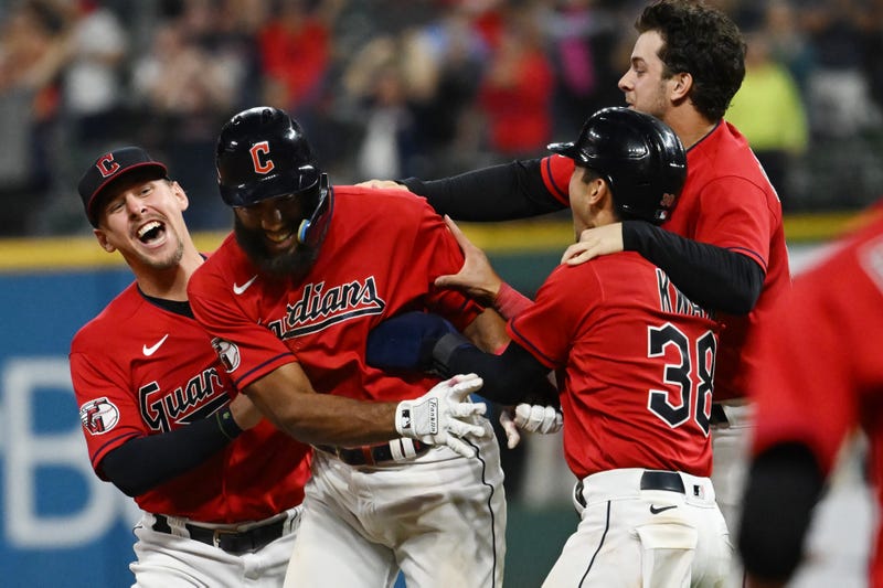Cleveland Guardians shortstop Amed Rosario, second left, celebrates with relief pitcher Kirk McCarty, left, left fielder Steven Kwan (38) and third baseman Ernie Clement, right, after Rosario hit an RBI single to win the game during the fifteenth inning against the Minnesota Twins at Progressive Field.