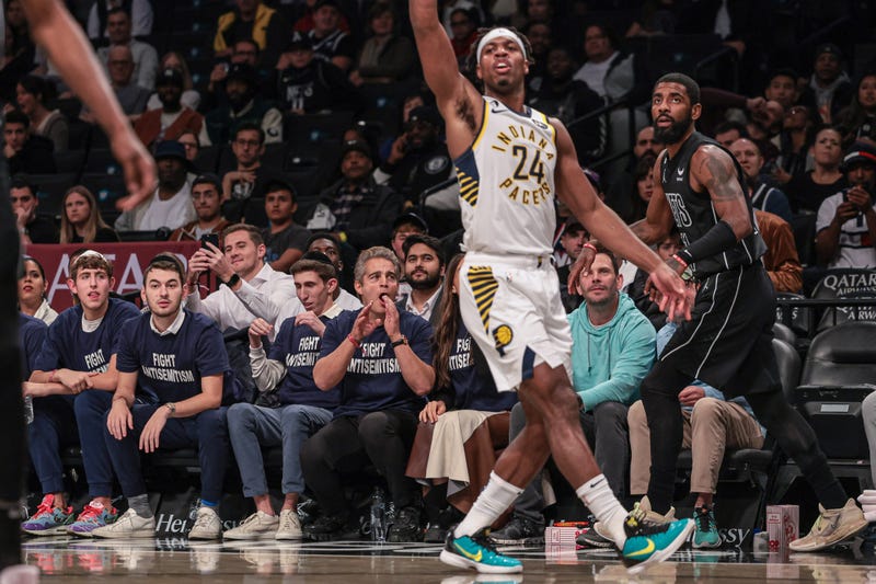 Oct 31, 2022; Brooklyn, New York: Fans wearing shirts with the phrase fight antisemitism react behind Brooklyn Nets guard Kyrie Irving (11) and guard Buddy Hield (24) during the first quarter at Barclays Center.