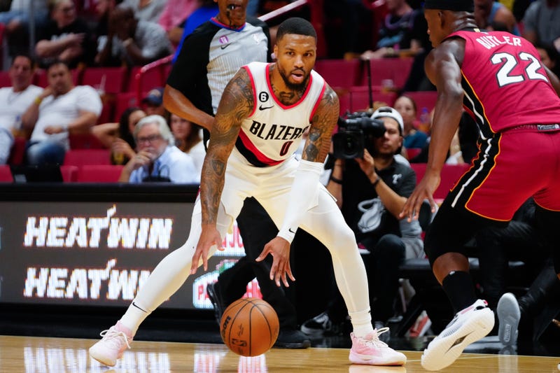 Damian Lillard dribbles the ball around Jimmy Butler
