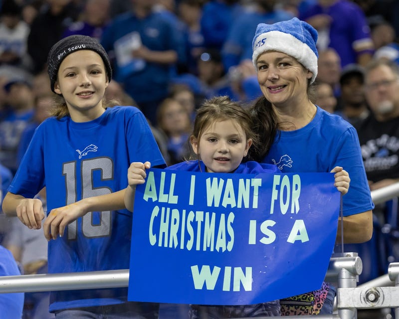 A young fan holds up her Christmas wish sign during the second half of a game between the Detroit Lions and the Minnesota Vikings at Ford Field